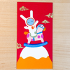 Red envelope with cartoon character on a wooden surface