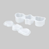White plastic multi-cavity mold set with three different shaped cavities, shown on a gray background.