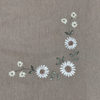 Embroidered floral design on a brown fabric background