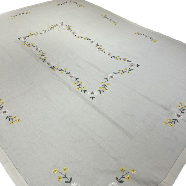 Embroidered floral pattern on a light gray tablecloth