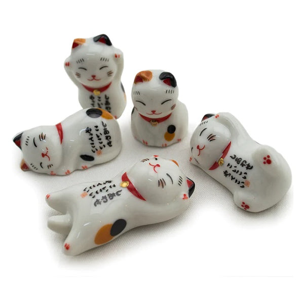 Ceramic lucky cat chopstick rest in different poses.