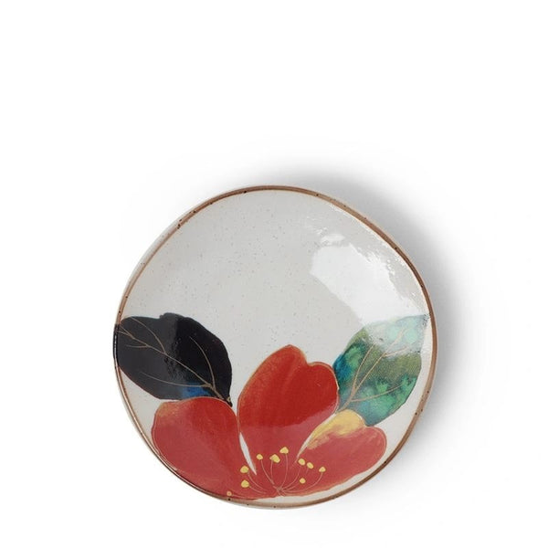 A small ceramic plate with a floral design, predominantly purple and green flowers with a brown rim.
