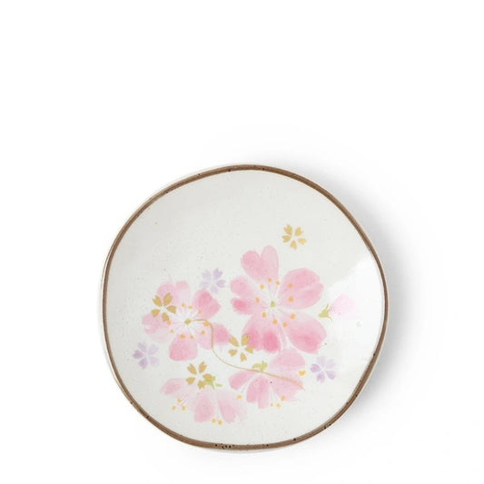 A small ceramic plate with a floral design, predominantly purple and green flowers with a gold rim.