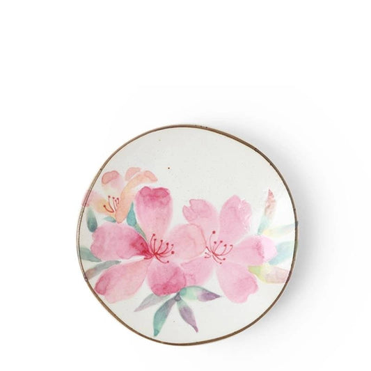 A small ceramic plate with a floral design, predominantly purple and green flowers with a gold rim.