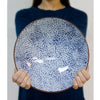 blue on white serving bowl held by a person in the background