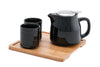 Black ceramic pot and cups on top of wooden tray