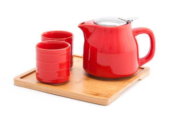 Red ceramic tea set on top of a wooden tray 
