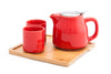 Red ceramic tea set on top of a wooden tray 