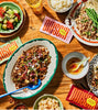 A collection of Southeast Asian food dishes with the individual sampler boxes by each dish.
