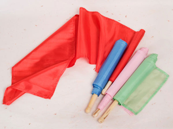 Four rolls of dancing ribbon, each in a different color: red, blue, green and pink. the red dancing ribbon is unrolled while the others are rolled up