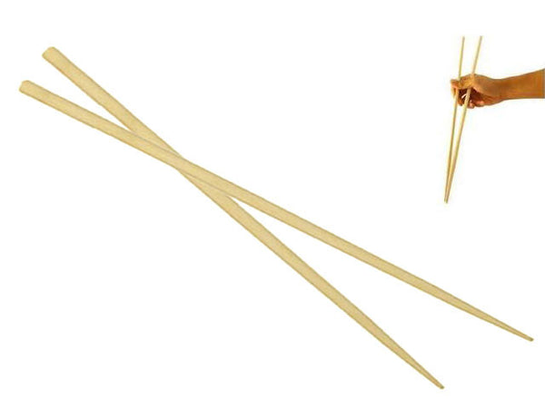 Two pairs of extra long chopsticks, the one on the right is being held by someone