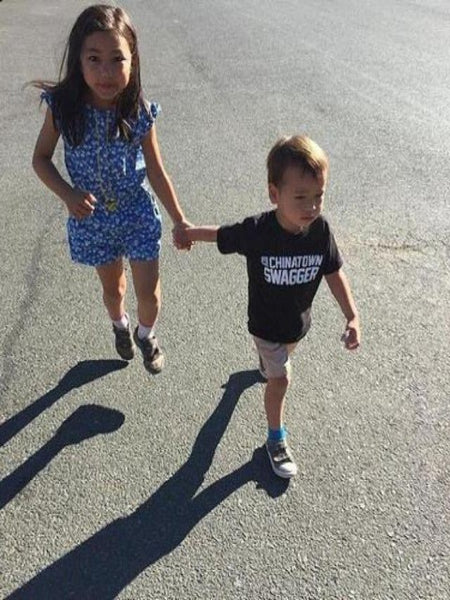 Little girl in a dress with a little boy wearing a cool black Chinatown Swagger T-shirt