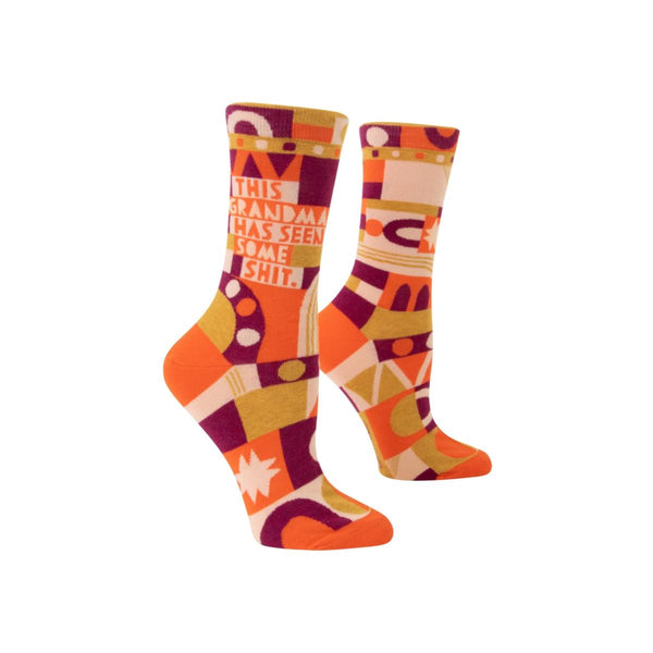 Psychedelic-patterned socks in purple, orange, and light gold, reads "this grandma has seen some shit."