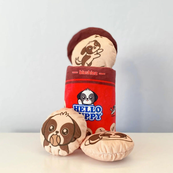 Hello Puppy Sneak-Treat Dog Toy: biscuit toy coming out of box with two biscuits on the counter, biscuits have different, cute puppy illustrations and the main box has the snack template for hello panda