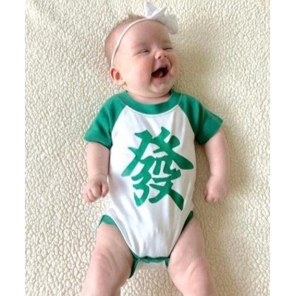 Laughing baby wearing mahjong onesie