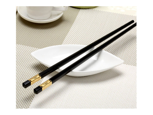 fortune design black chopstick resting on ceramic dish