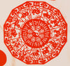Another design of an intricate red paper cut decoration featuring the animals of the Chinese zodiac and a yin yang symbol at the center