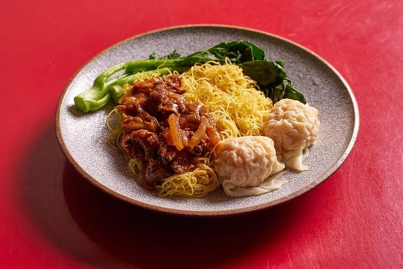 Dish with wontons, noodles with sauce, and Chinese broccoli